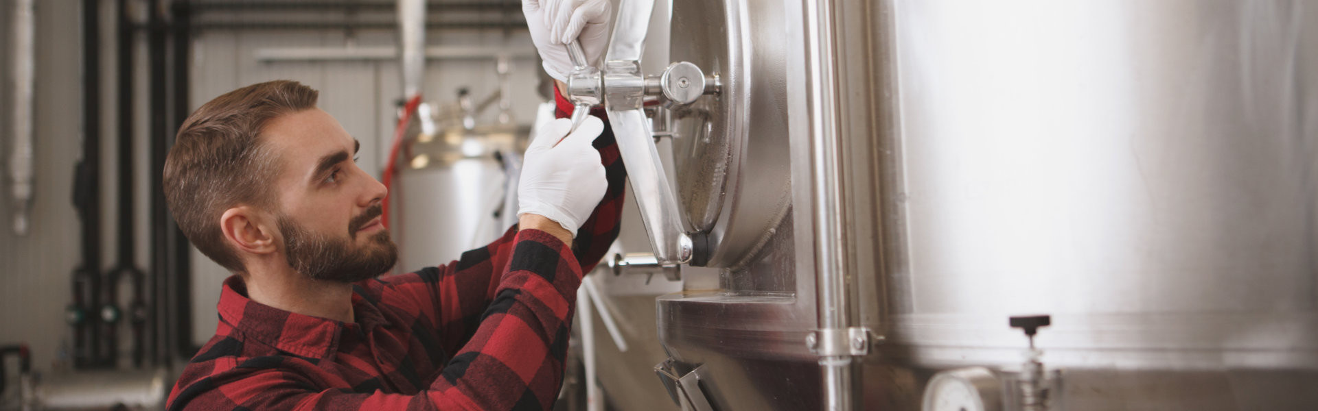 Craft Brewery Male Staff Adjusting Storage Tank Lock